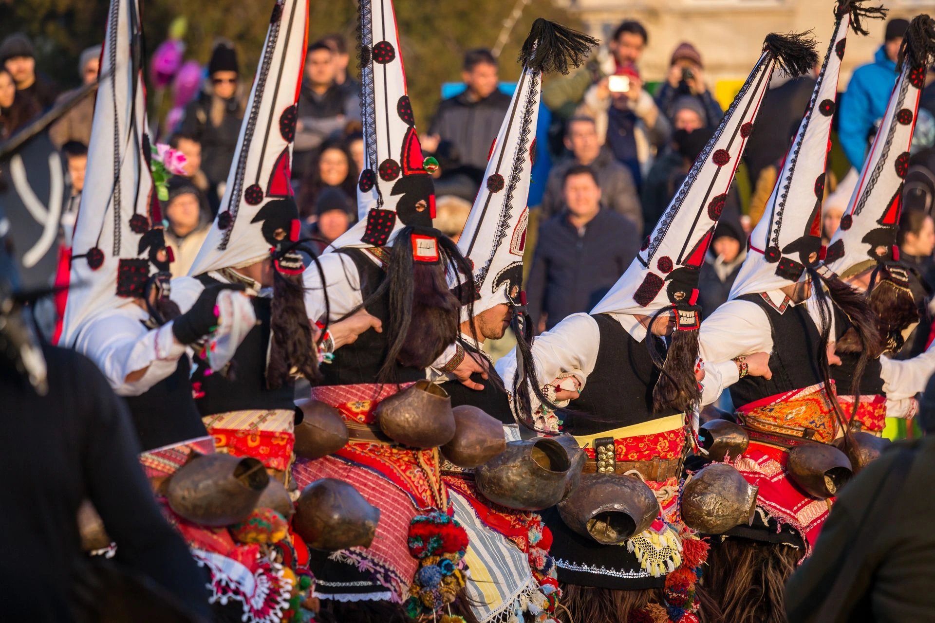 Bulgarian Kukeri performers dancing during a traditional winter ritual