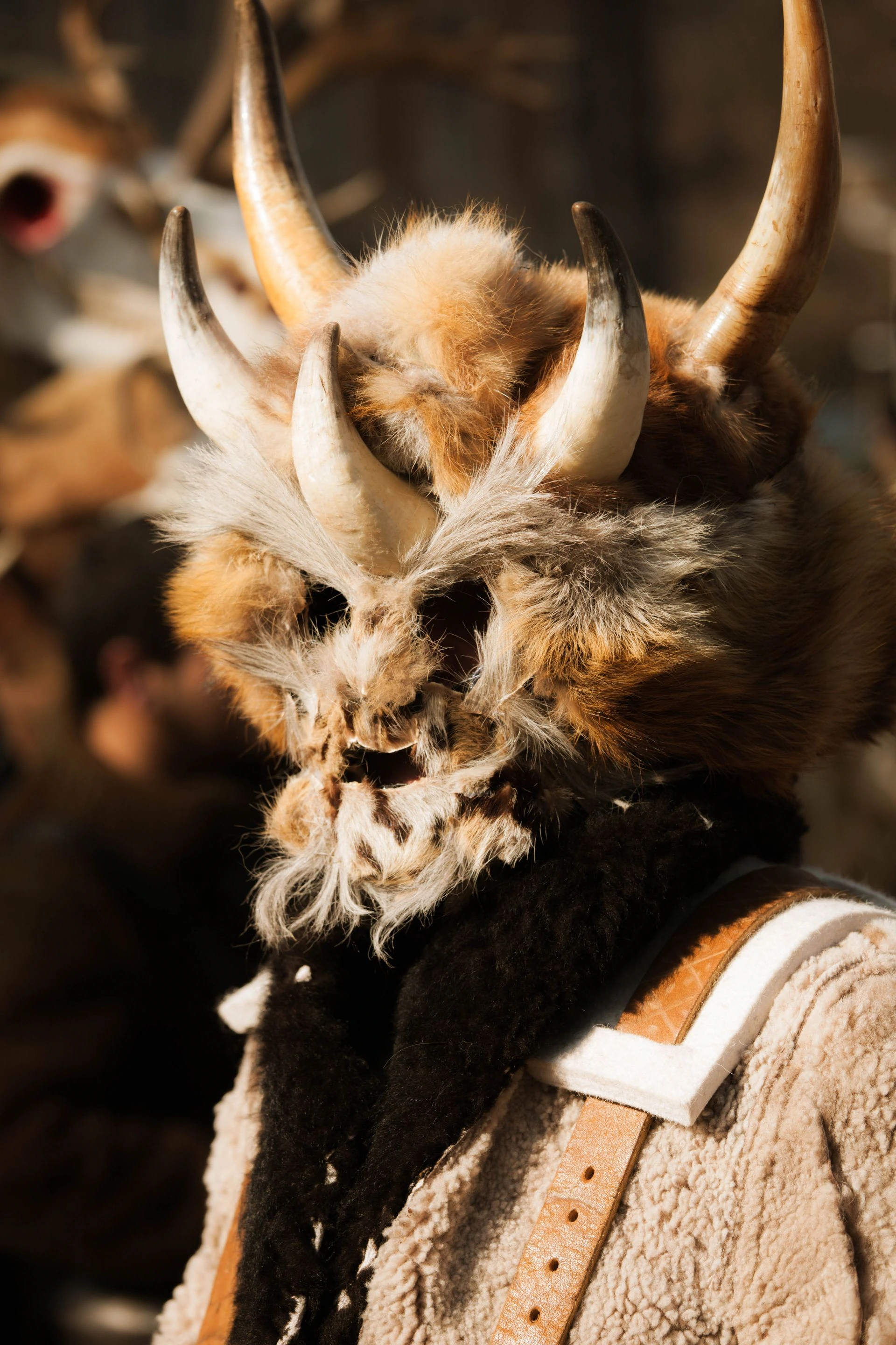 Close-up of a traditional Bulgarian Kukeri mask decorated with feathers and wool